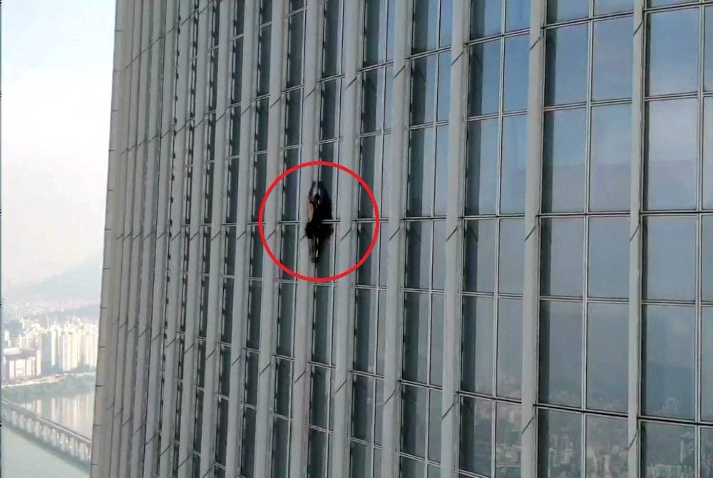 A British man climbs South Korea's tallest building, the 123-storey Lotte World Tower, without a rope before being forced to abandon the climb more than halfway up, in Seoul, South Korea, June 12, 2023. South Korea's Songpa Fire Station/Handout via REUTERS