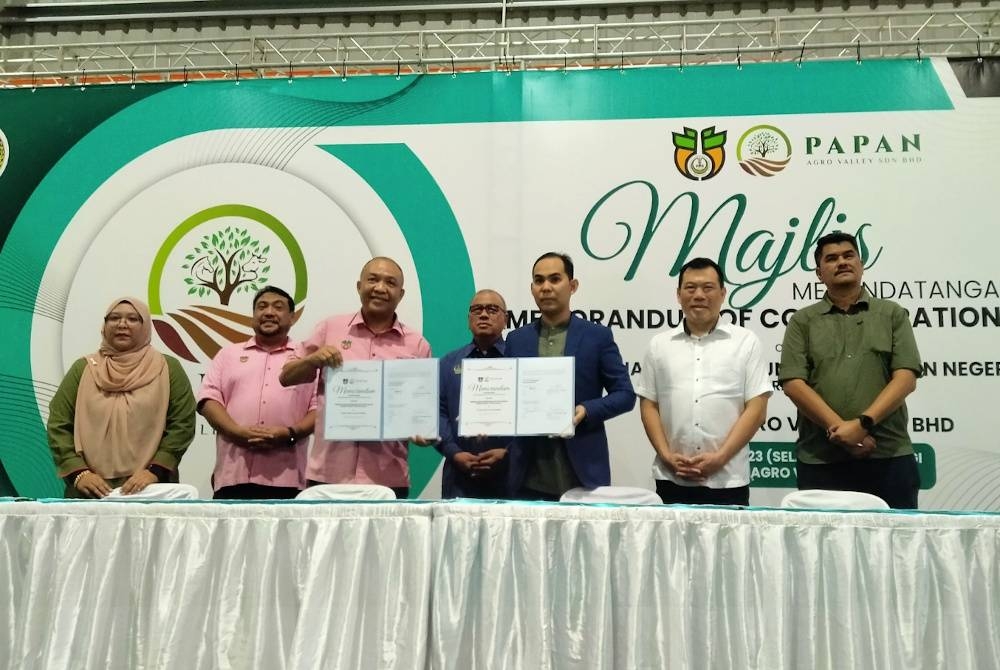 Mohd Zolkafly (tengah) menyaksikan pertukaran dokumen Majlis Menandatangani Memorandum Kerjasama di antara Perak SADC dengan Papan Agro Valley Sdn Bhd di Lot 51300 Mukim Belanja, di sini pada Selasa.