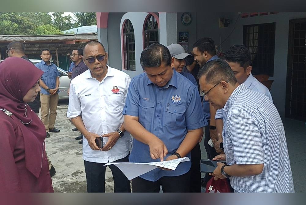 Mohd Haffiz (dua dari kanan) melihat pelan perancangan yang akan dilakukan di Sungai Gelang Patah.