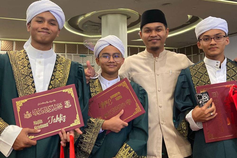 Anwar (kiri) bergambar kenangan bersama rakan dan guru selepas menerima sijil khatam hafazan al-Quran sempena Majlis Graduasi Tahfiz Yayasan Islam Kelantan 2022.