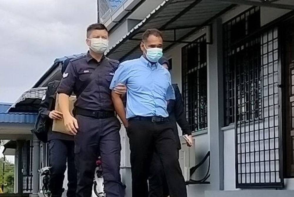 Tertuduh diiringi anggota polis keluar dari mahkamah selepas selesai pertuduhan.