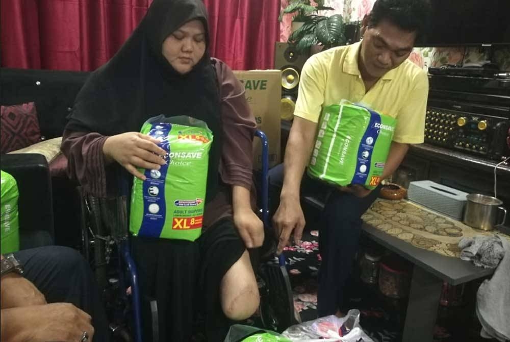 Fadzil (kanan), menunjukkan bahagian kaki Fazlenyana yang dibuang akibat kencing manis.