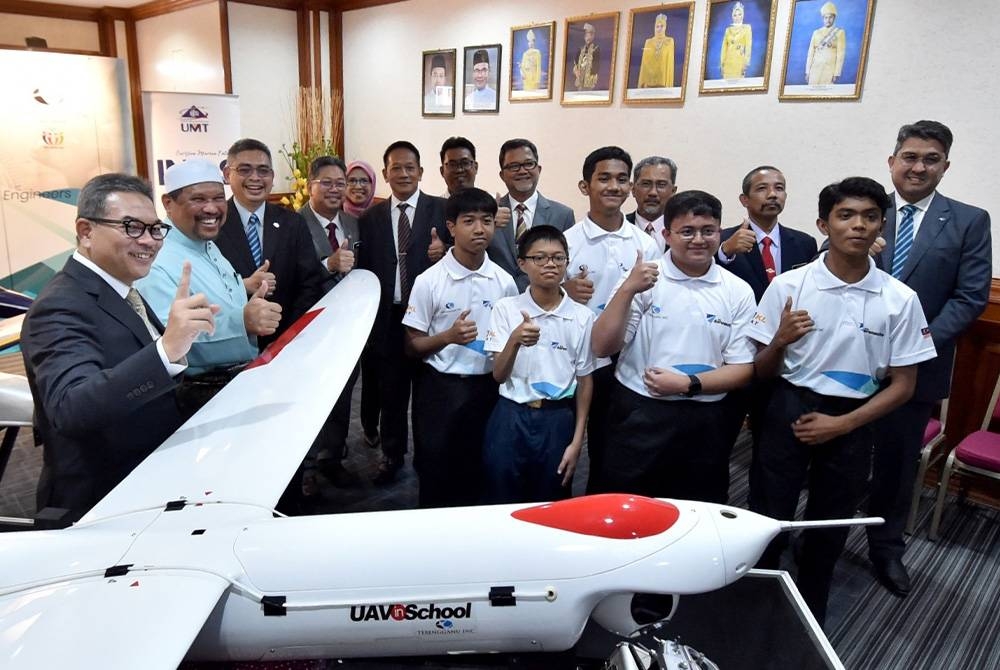 Burhanuddin (tiga dari kiri) bersama Satiful Bahri (dua dari kiri) dan Tengku Farok (kiri) ketika hadir pada Program TI-BSas Aeronautics UAV In-School di Wisma Darul Iman, di Kuala Terengganu pada Rabu.