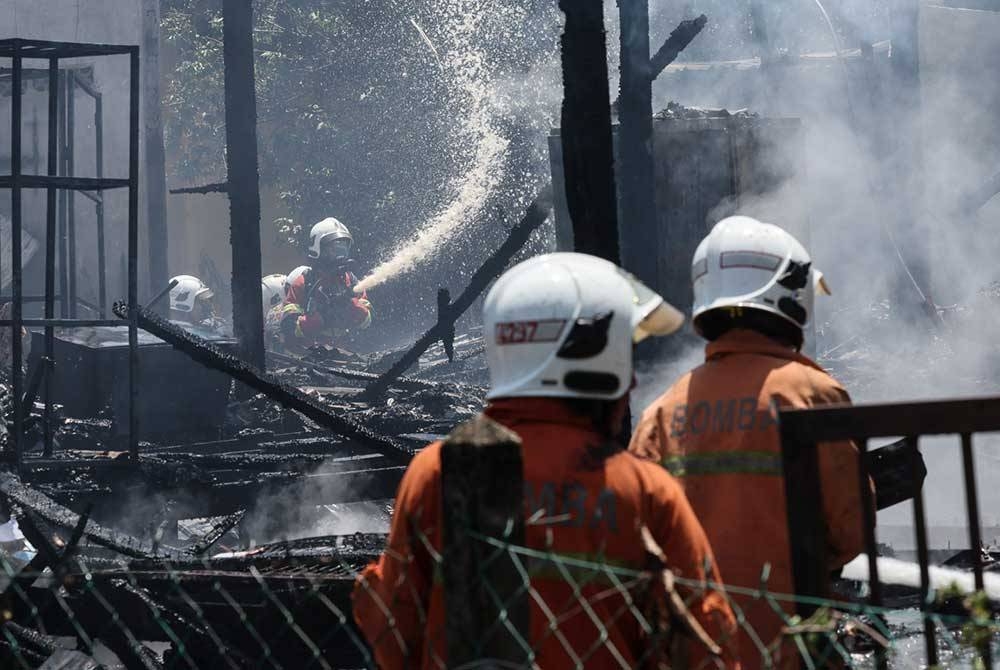 Anggota Jabatan Bomba dan Penyelamat Malaysia bertungkus-lumus memadamkan kebakaran di sebuah rumah di Kampung Gong Datuk pada Rabu. - Foto Bernama