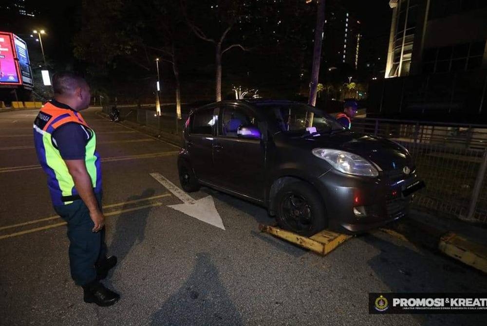 Sebuah kereta yang ditunda selepas di parkir di bahu jalan. - Foto Facebook DBKL