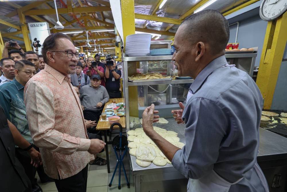 Anwar beramah mesra bersama seorang peniaga pada Majlis Temu Mesra Perdana Menteri di Pusat Penjaja MADANI Jalan Tuanku Abdul Rahman Lestari Niaga@Kuala Lumpur di Chow Kit pada Khamis - Foto Bernama