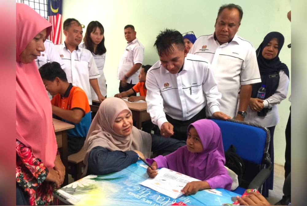 Fadhlina (dua dari kiri) bermesra dengan pelajar di Sekolah K9 SK Pulau Beluru, Tumpat.