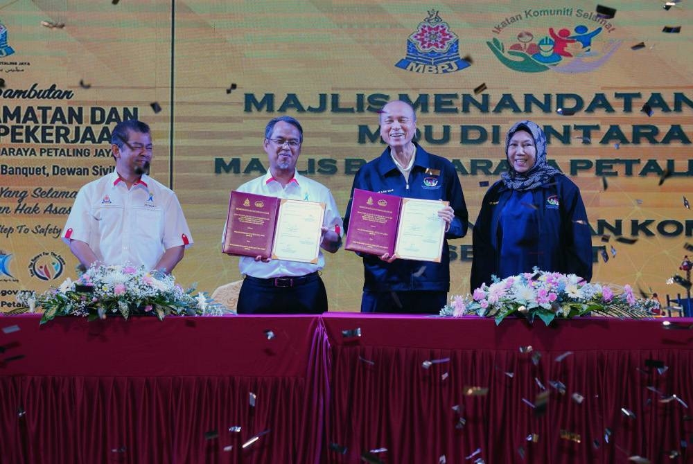 Mohamad Azhan (dua dari kiri) dan Lam Thye (dua dari kanan) bertukar dokumen perjanjian pada Sambutan Hari Keselamatan dan Kesihatan Pekerjaan Peringkat MBPJ di Dewan Sivik pada Selasa. - Foto SINAR HARIAN / MOHD HALIM ABDUL WAHID.