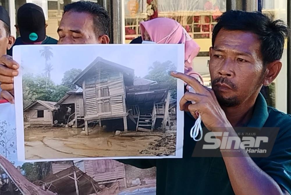 Nor Samsi menunjukkan rumah penduduk yang mengalami kerosakan akibat kejadian banjir.