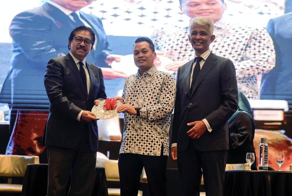 Nik Nazmi (tengah) menerima penghargaan daripada Pengerusi MIDF, Tan Sri Abdul Rahman Mamat (kiri) pada Majlis Persidangan Hijau MIDF 2023 pada Khamis. - Foto Bernama