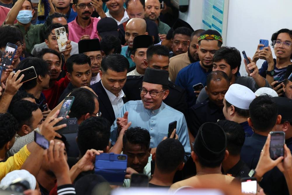 Anwar bersalaman dengan para jemaah selepas menunaikan solat Jumaat di Masjid Raja Haji Fisabilillah, pada Jumaat. - Foto Bernama