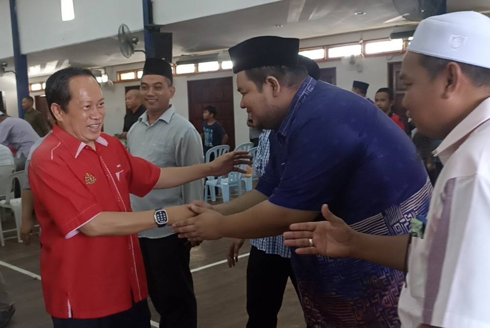 Ahmad (kiri) bersalaman dengan ibu bapa yang hadir pada Mesyuarat Agung PIBG SMA Bugisiah, Tampok Benut, Pontian pada Sabtu.