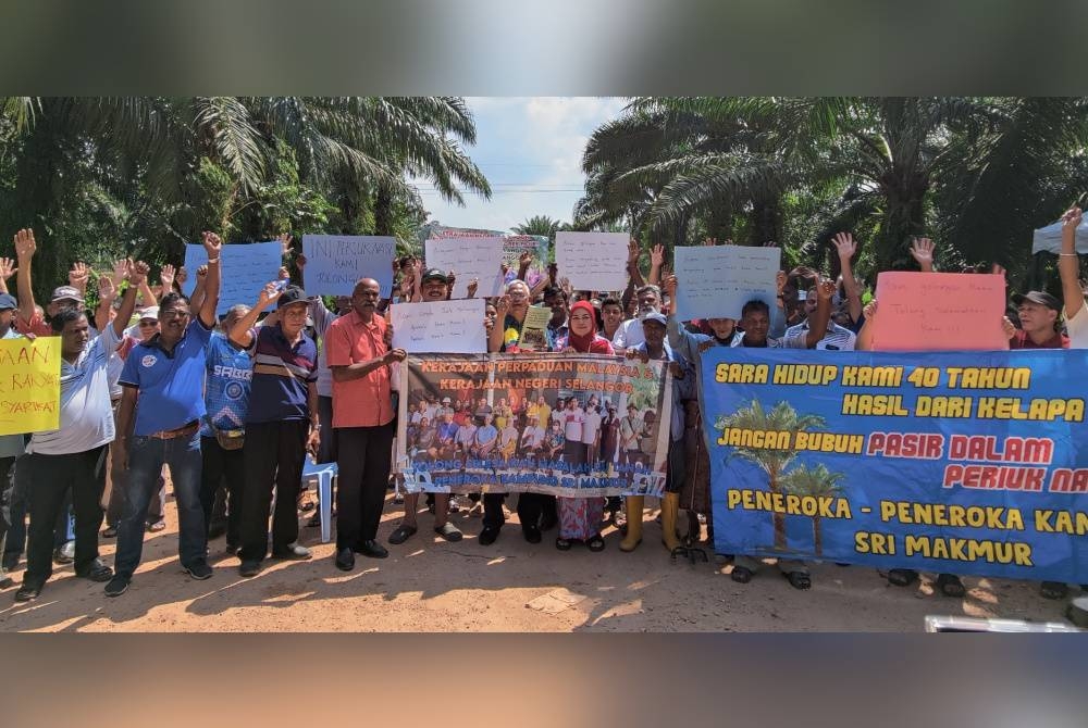 Noh (tengah) bersama-sama peneroka bergambar selepas Program Dialog Bantahan Pengambilan Tanah Peneroka di Kampung Seri Makmur di sini pada Sabtu.