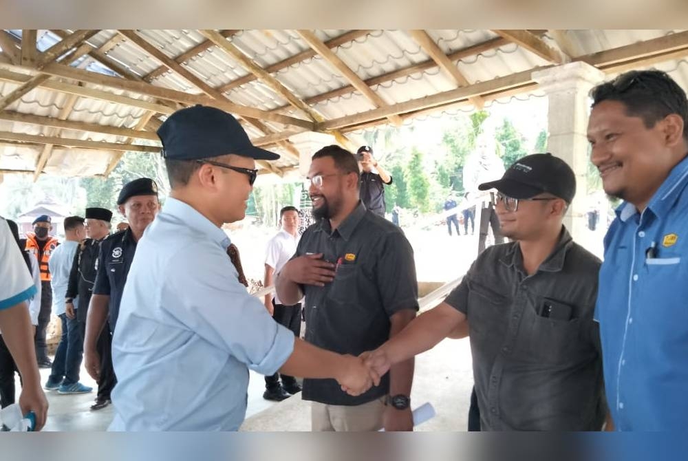 Nik Nazmi (kiri ) ketika tiba di Klinik Kesihatan Teluk Renjuna sempena Program Lawatan ke Projek Pembangunan Persekutuan Negeri Kelantan pada Sabtu.