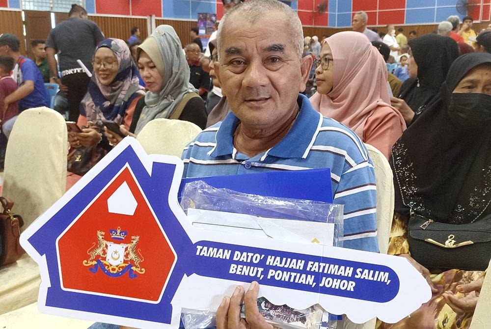 Daim antara penerima kunci rumah baharu di Taman Datuk Hajjah Fatimah Salim, Benut.