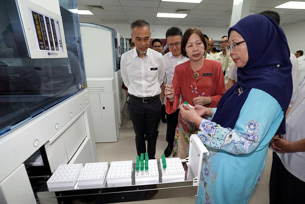 Dr Zaliha melihat mesin untuk pemeriksaan sampel darah di unit makmal patologi kimia sambil diberi penerangan pada Majlis Penyerahan Projek Makmal Patologi HSA Johor Bahru, Klinik Kesihatan Taman Ungku Tun Aminah Johor Bahru dan Klinik Kesihatan Palong Timur, Segamat di HSA hari ini. - Foto Bernama