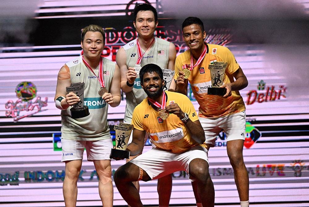 Aaron (kiri) dan Wooi Yik bersama Satwiksairaj-Chirag (kanan) selepas perlawanan akhir beregu lelaki badminton Terbuka Indonesia di Jakarta pada Ahad. - Foto AFP