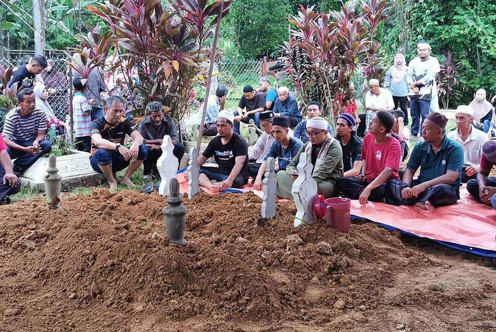 Jenazah tiga beranak selamat disemadikan dalam satu liang di Tanah Perkuburan Islam Kampung Sekati, Manir, di Kuala Terengganu pada Ahad.