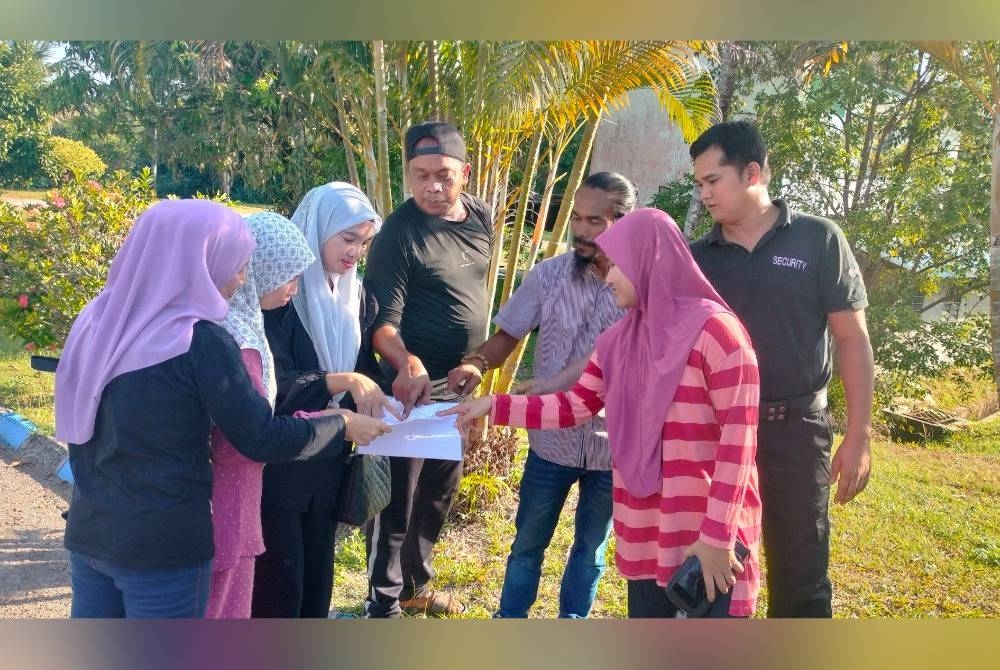 Nurul Hasnal (dua dari kanan), Arida (tiga dari kanan) dan Mohd Khairil (dua dari kiri) bersama ibu bapa lain menunjukkan laporan perbelanjaan yang didakwa gagal diperjelaskan secara terperinci oleh YDP dan guru besar di sebuah sekolah rendah di Paloh Hinai ketika ditemui pemberita di Balai Polis Paloh Hinai.