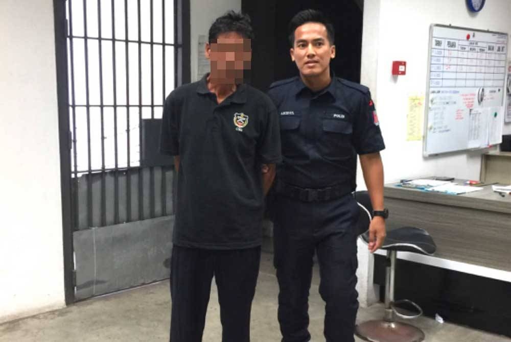 Mohd Adnan (kiri) dikawal polis keluar dari Mahkamah Majistret selepas didenda.