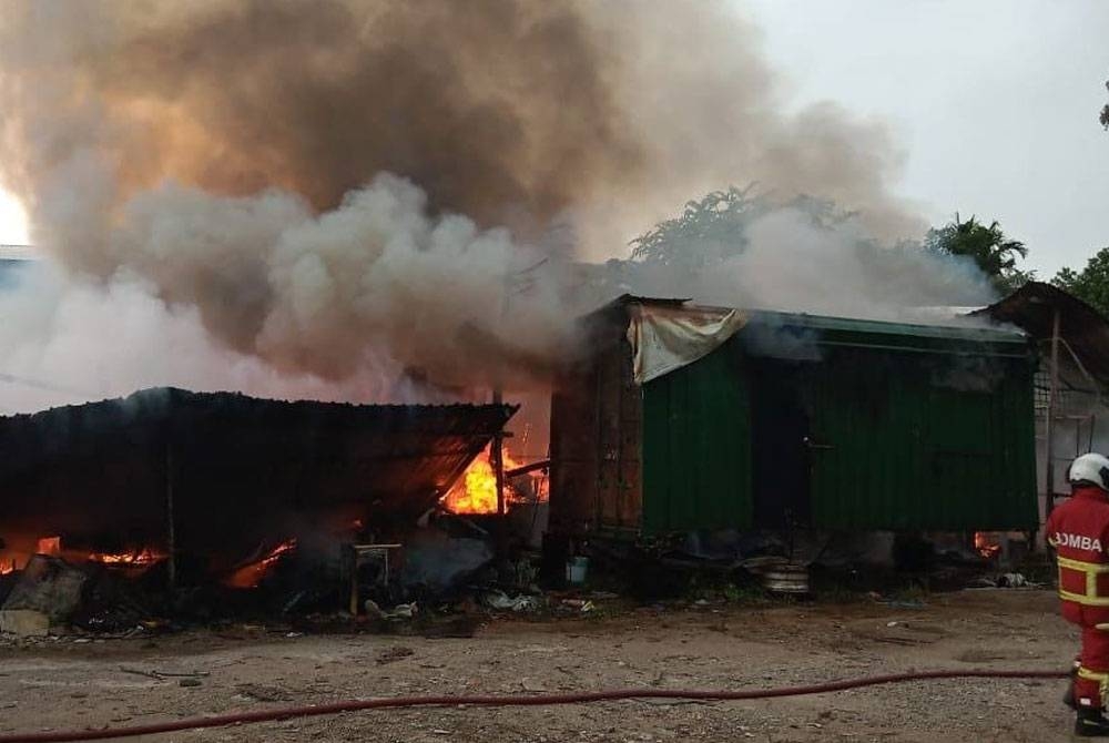 Anggota bomba memadamkan kebakaran di sebuah bengkel barangan terpakai di Batu 35, Jalan Johor, Pontian, pada Selasa.