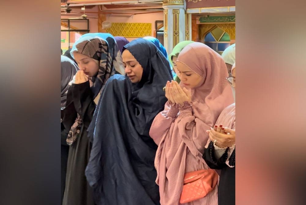 Kila (tengah) diapit oleh Tya dan Izara ketika solat jenazah Rohana Jalil di Masjid Al-Falah, USJ9, di sini