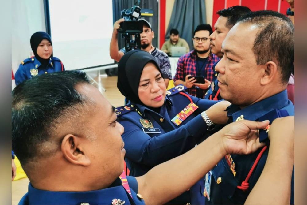 Sayani bersama Penolong Pengarah Bahagian Operasi JBPM Perak, Sabarodzi Nor Ahmad menyempurnakan Pemakaian Tanda Pangkat kepada 24 pegawai di Ibu Pejabat JBPM Perak pada Rabu.