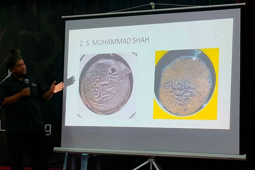 Jisham menunjukkan mata wang syiling dan tampang Kesultanan Melayu Pahang pada program bicara@muzium 2023 anjuran Muzium Sungai Lembing di panggung wayang lama PCCL, Sungai Lembing pada Khamis.