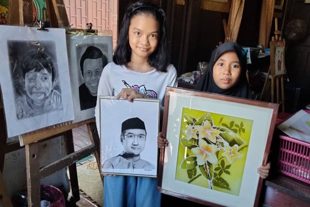 Fatimah Aisyah (kanan) dan Fatimah Az Zahra bersama lukisan mereka.