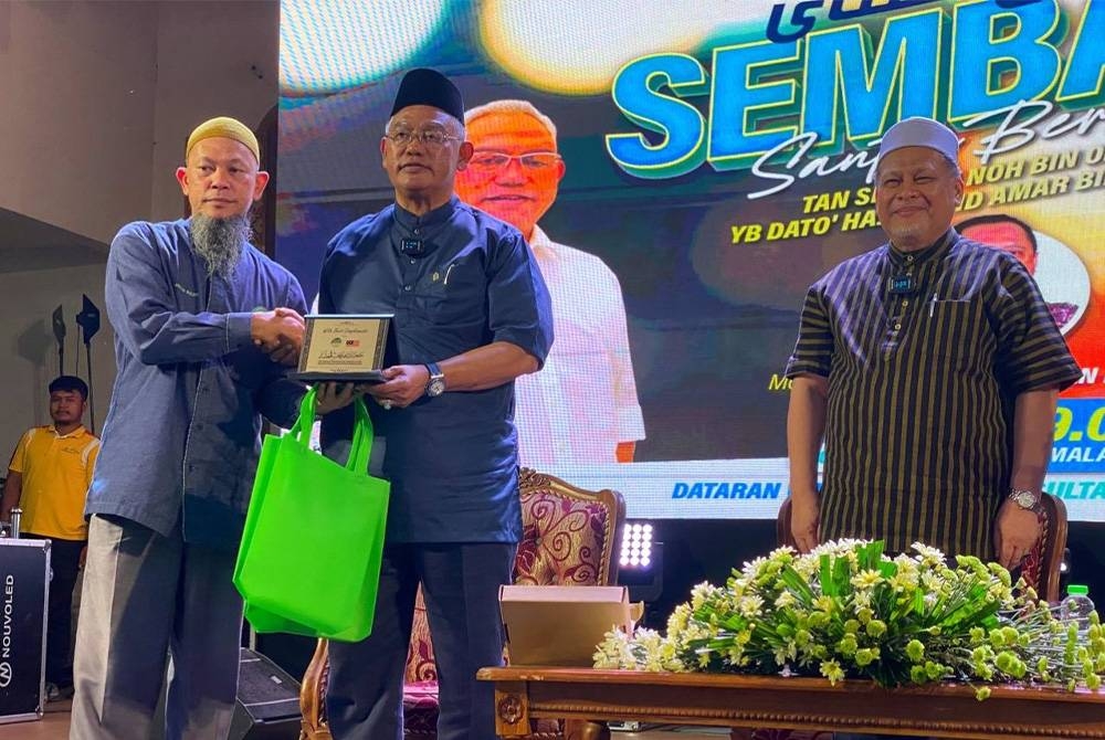 Noh (dua dari kiri) menerima cenderamata semasa hadir ke Program Sembang Santai Bersama beliau sempena Karnival Kelantan Maju Rakyat Sejahtera di Dataran Warisan, Stadium Sultan Muhammad IV, Kota Bharu pada malam Khamis.