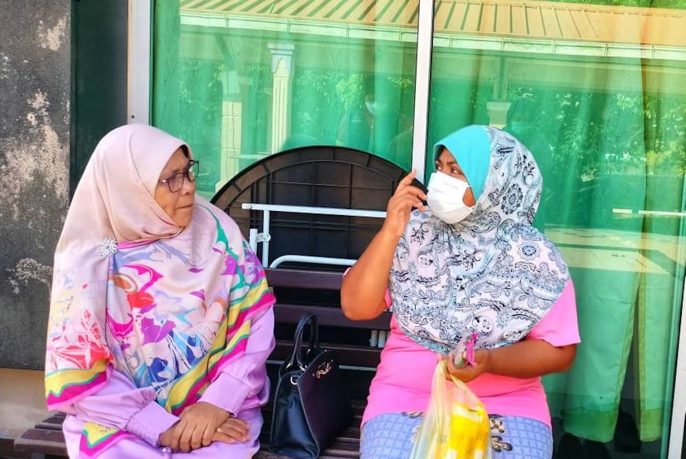 Siti (kanan) ketika menceritakan pengalaman tinggal dalam kereta bersama suaminya kepada Salamiah ketika ditemui di sini pada Jumaat