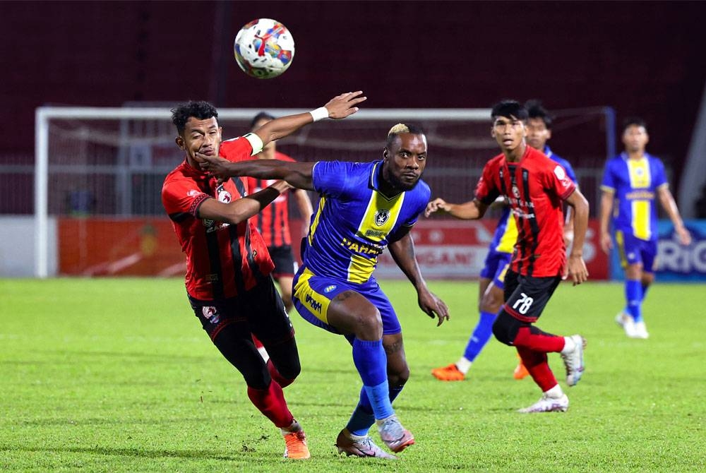 Pemain Sri Pahang FC Kpah Seam Sherman (tengah) diasak pemain Pemain Kelantan FC Muhammad Yusri Yuhasmadi (kiri) dalam aksi perlawanan Liga Super di Stadium Sultan Muhammad Ke-IV di sini malam ini.- Foto Bernama.