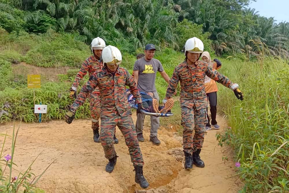 Anggota bomba menggunakan peralatan pengusung bagi membawa seorang pendaki wanita yang mengalami gastrik semasa mendaki Bukit Botak Bandar Puncak Alam pada Sabtu.