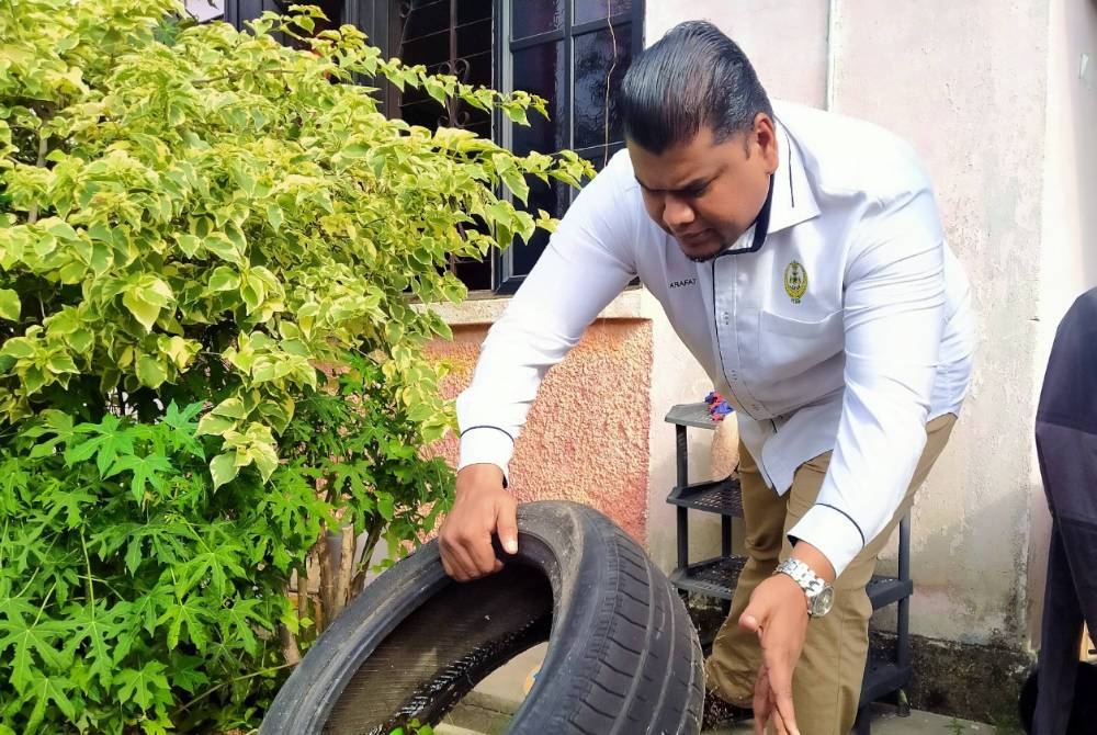 Muhamad Arafat turut memeriksa tayar terpakai di rumah penduduk sempena Gotong-Royong Mega 1.0 dan Pelancaran One Hour Malaysia Clean Up Peringkat Negeri Perak di Kampung Tersusun Batu 5, Tambun pada Sabtu.