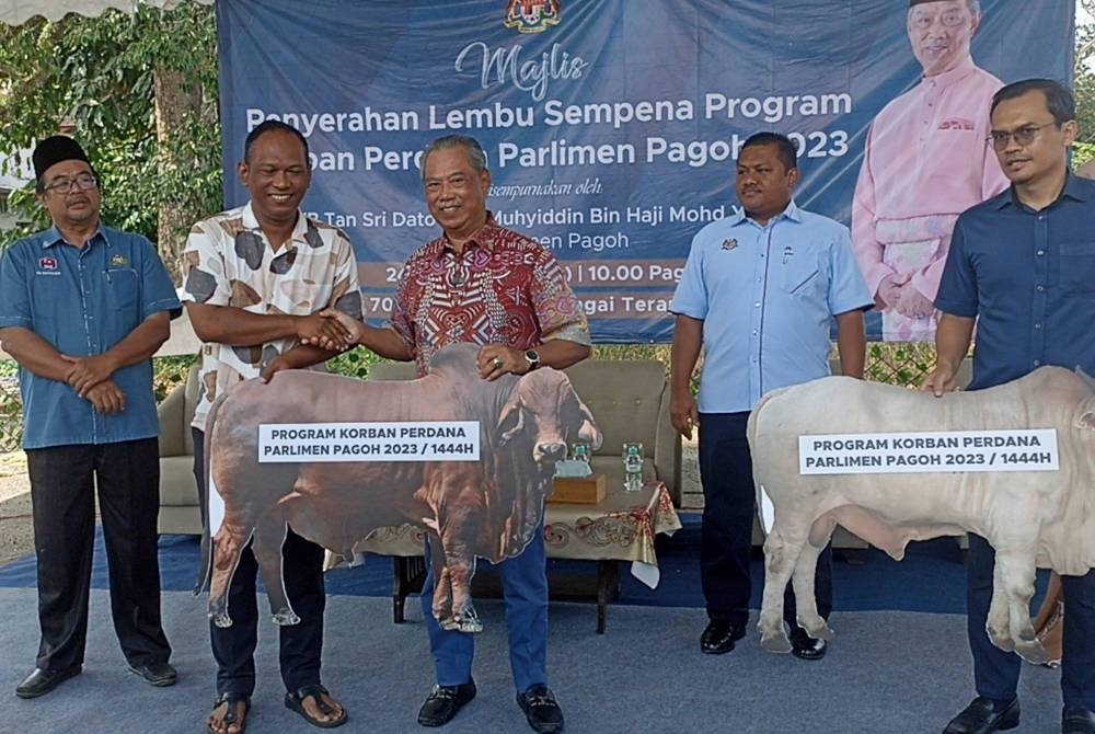 Muhyiddin (tengah) menyerahkan sumbangan lembu korban bagi Parlimen Pagoh di Bukit Pasir pada Sabtu.