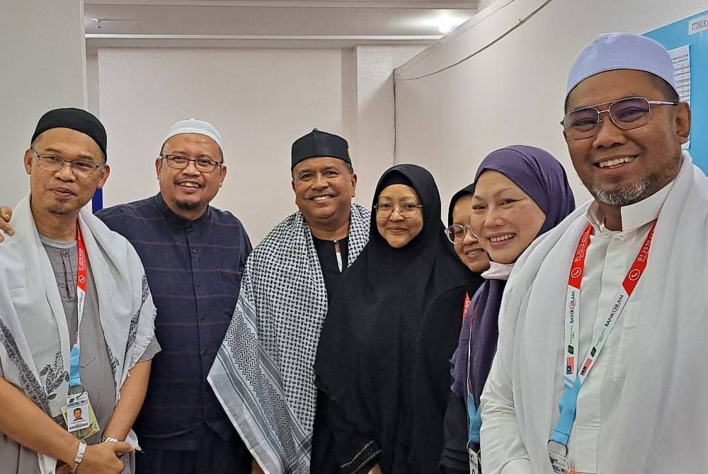 Subadron (tiga dari kiri) dan Salwa (empat dari kiri) bergambar bersama jemaah haji dari Sarawak ketika ditemui di Makkah.