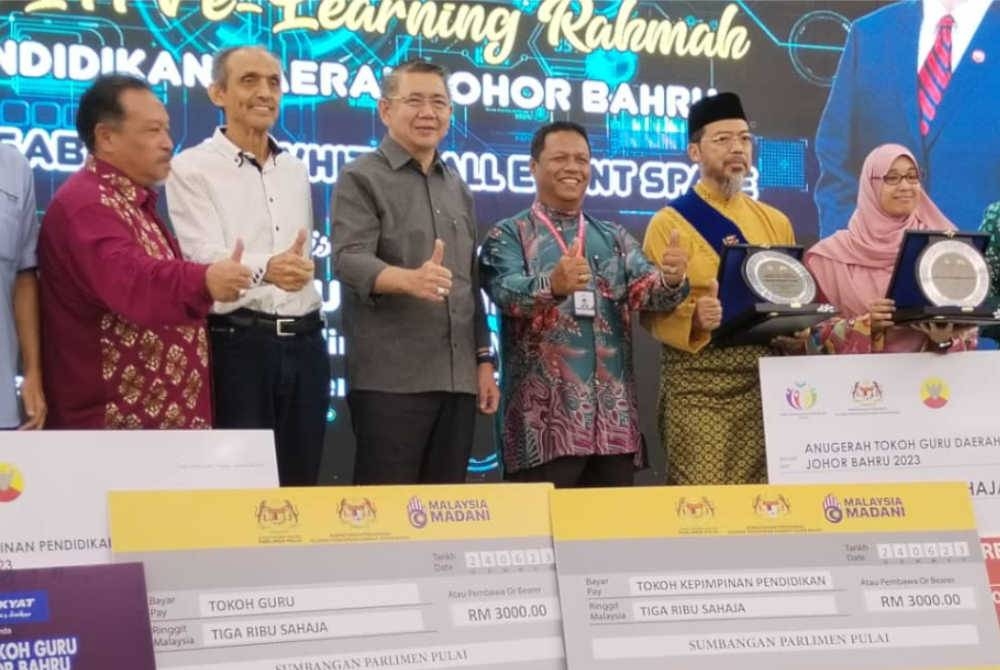 Salahuddin (tiga, kiri), bersama dua penerima anugerah Guru Cemerlang, pada program berkenaan.