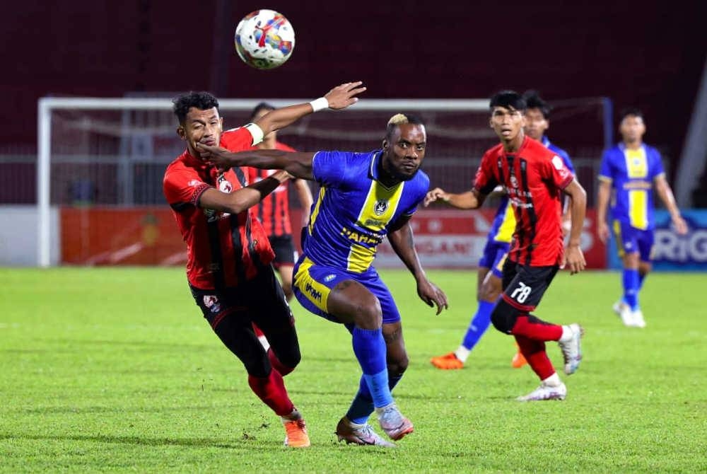 Kpah Sherman (tengah) diasak pemain Kelantan, Muhammad Yusri Yuhasmadi (kiri) dalam aksi Liga Super di Stadium Sultan Muhammad IV, Kota Bharu malam ini. - Foto: Bernama