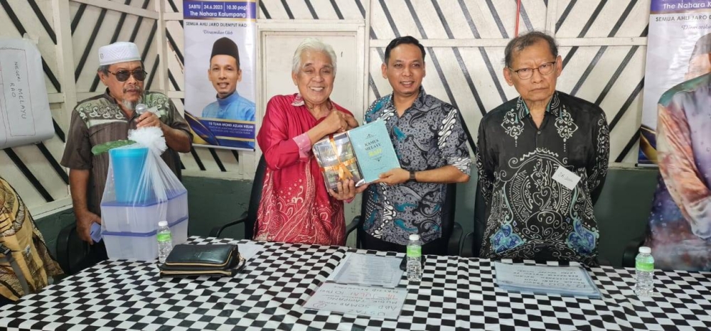 Mohamed (kiri) menyerahkan buku terbitan Jaro kepada Mohd Azlan pada Majlis Perasmian Mesyuarat Agung Tahunan Jaro ke-10 di The Nahara Kalumpang pada Sabtu.