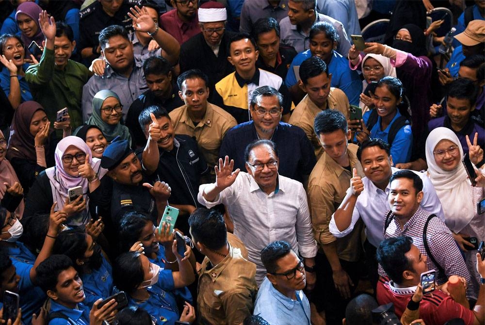 Anwar melambaikan tangan ke arah jurufoto semasa hadir pada program Temu Anwar di USIM hari ini. - Foto Bernama