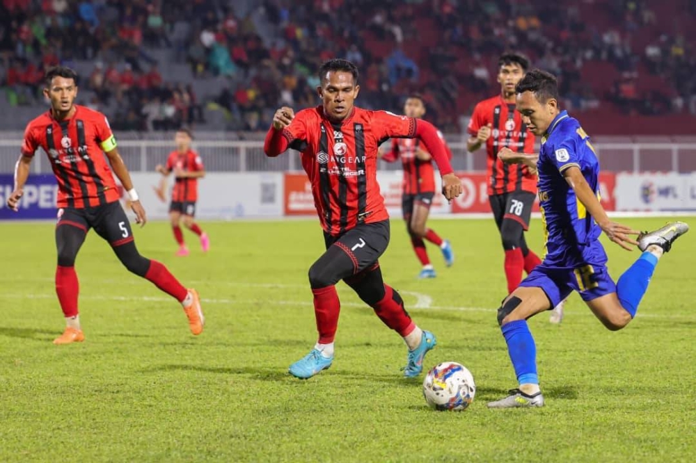 Pemain Kelantan, Mohd Arip Amiruddin (tengah) berusaha mengasak bintang Sri Pahang FC, Muhamad Baqiuddin Shamsudin (kanan) dalam aksi Liga Super di Stadium Sultan Muhammad IV, Kota Bharu pada Jumaat.