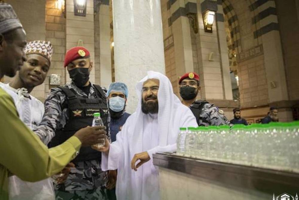 Abdulrahman menyantuni para tetamu Allah sambil menghulurkan botol air zamzam kepada jemaah haji dan petugas di Masjid Nabawi, Madinah. - Foto Haramain Info