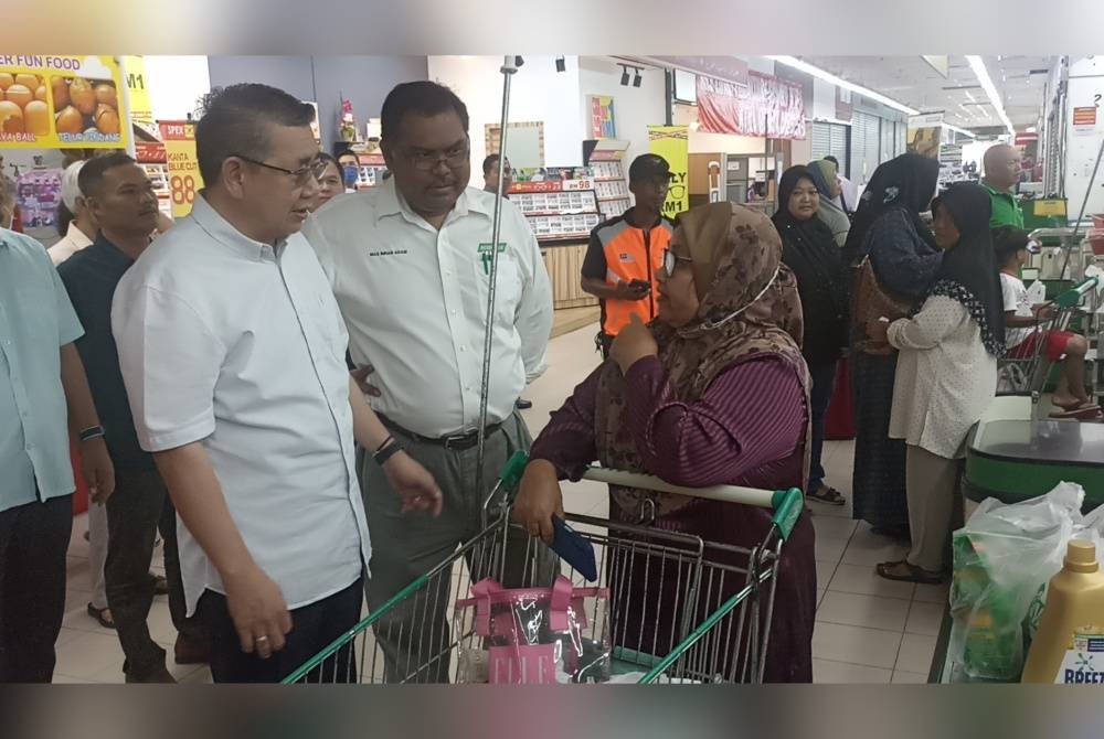 Salahuddin (kiri) beramah mesra dengan pengguna di Pasaraya Econsave Muar pada Selasa.