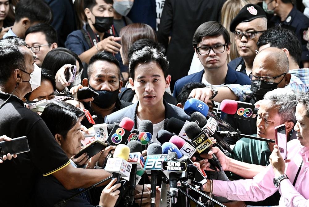 Pita (tengah) dikerumuni petugas media ketika keluar dari bangunan Parlimen di Bangkok pada Selasa. - Foto AFP