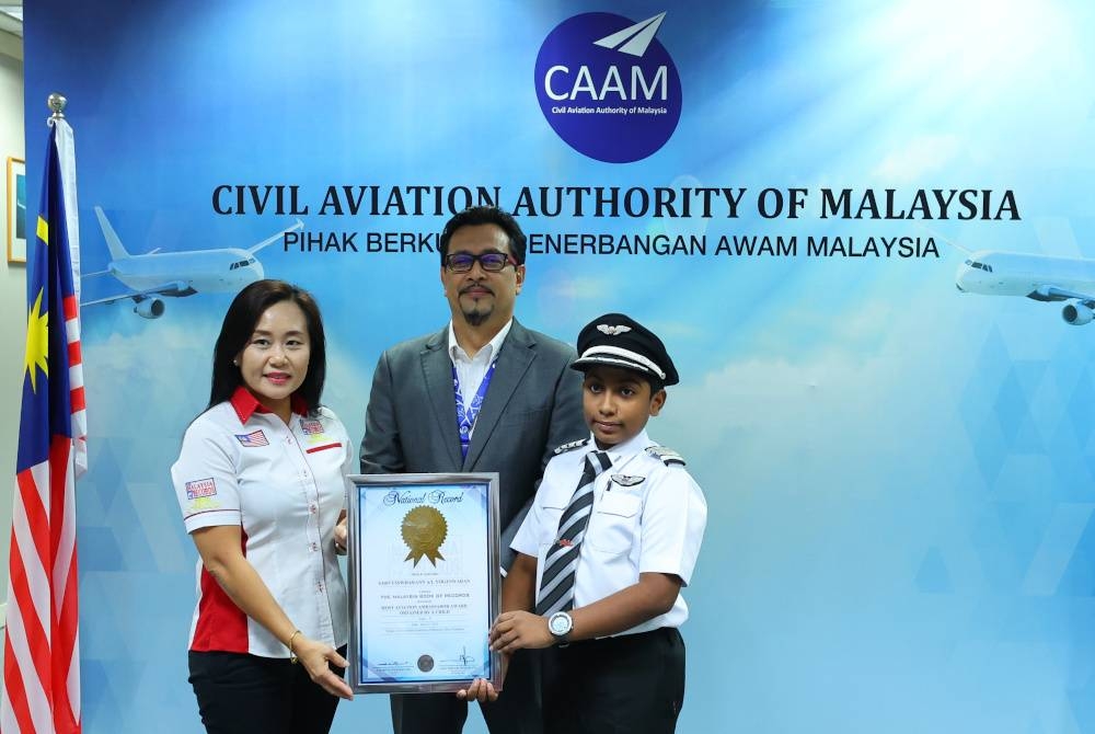 Norazman (tengah) menyaksikan penyampaian sijil anugerah &#039;Malaysia Book of Record 2023: Most Aviation Ambassador Awards Obtain By A Child&#039; oleh Poi Leng (kiri) kepada Sarvysswharrann di Podium B CAAM pada Selasa. - Foto Bernama