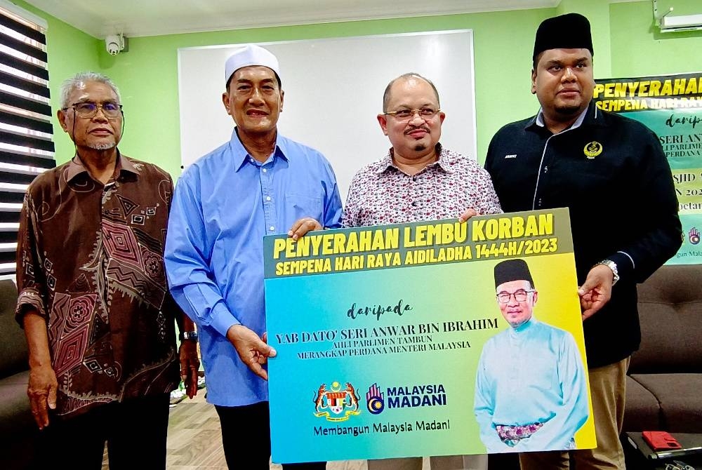 Shamsul Iskandar (dua dari kanan) menyampaikan kad simbolik penyerahan lembu korban kepada Pengerusi Masjid Al-Amaniyyah, Sukiman Jalil (dua dari kiri) pada program Penyerahan Lembu Korban Parlimen Tambun sempena Hari Raya Aidiladha.