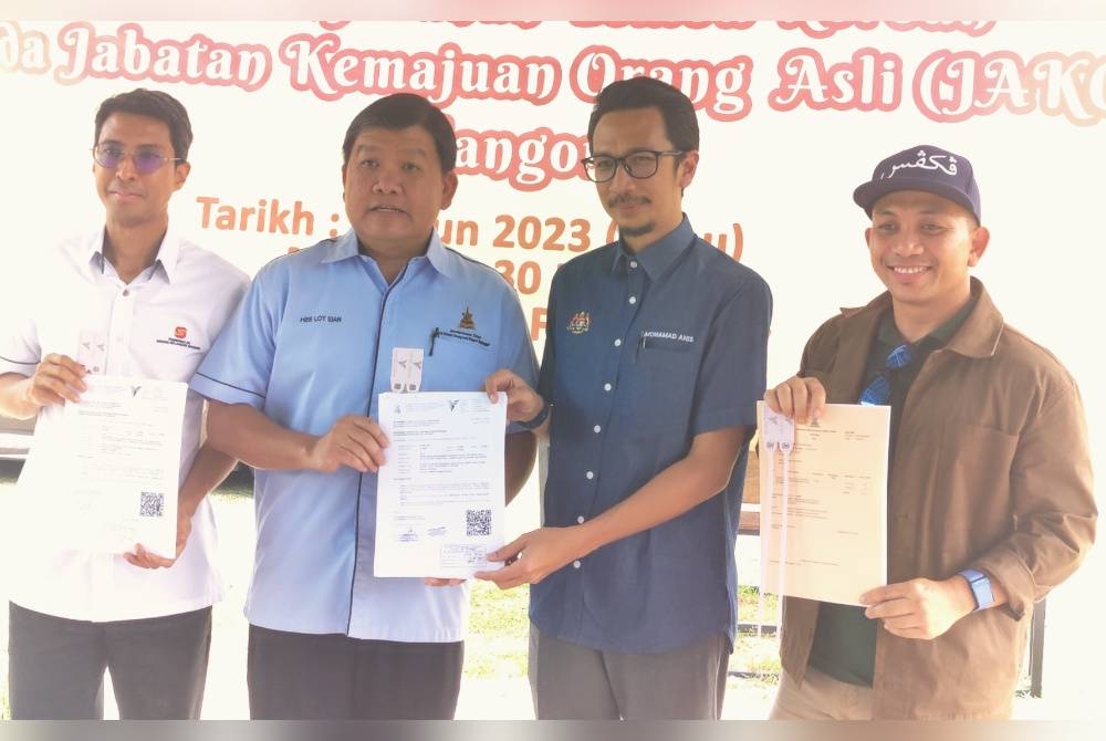 Loy Sian (dua dari kiri) menyerahkan dokumen penyerahan lembu korban kepada wakil JAKOA Selangor dalam satu majlis di Selangor Fruit Valley pada Rabu.