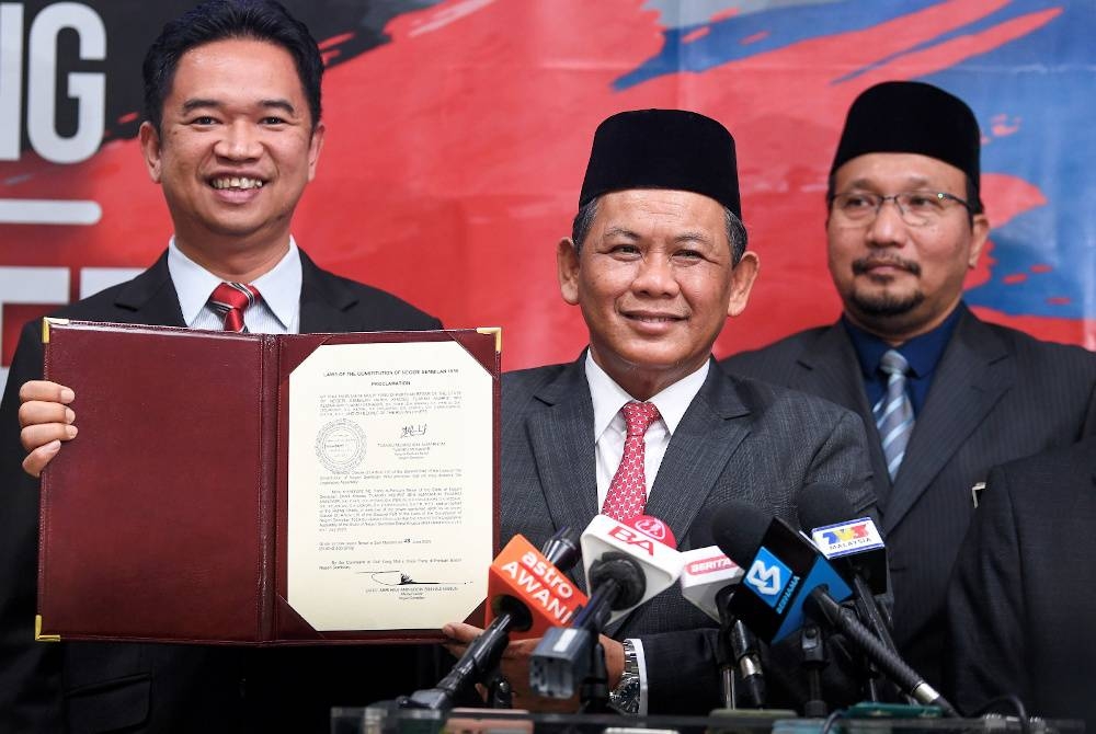 Aminuddin Harun (tengah) menunjukkan watikah pembubaran Dewan Undangan Negeri (DUN) Negeri Sembilan pada sidang media di Wisma Negeri, pada Rabu. - Foto Bernama