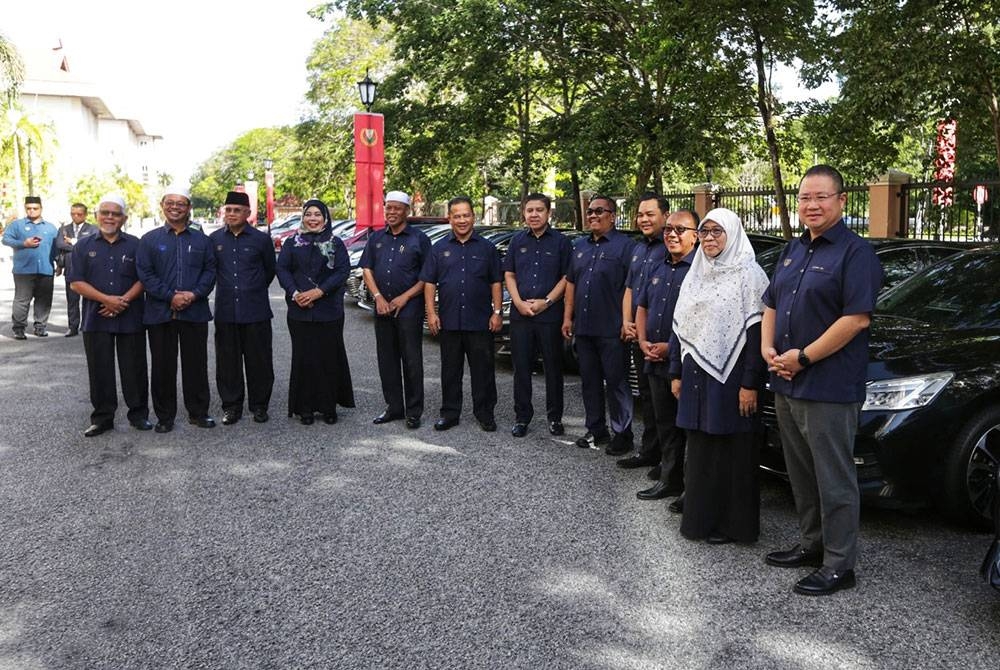 Muhammad Sanusi bersama barisan Exco kerajaan negeri bergambar di hadapan kenderaan rasmi selepas majlis penyerahan kunci di Wisma Darul Aman di sini pada Rabu.