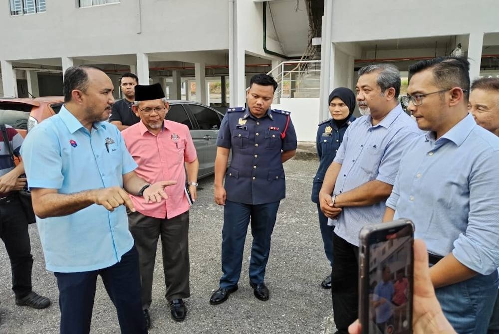 Mohd Jafni (kiri), berkata sesuatu ketika melakukan lawatan berkenaan.